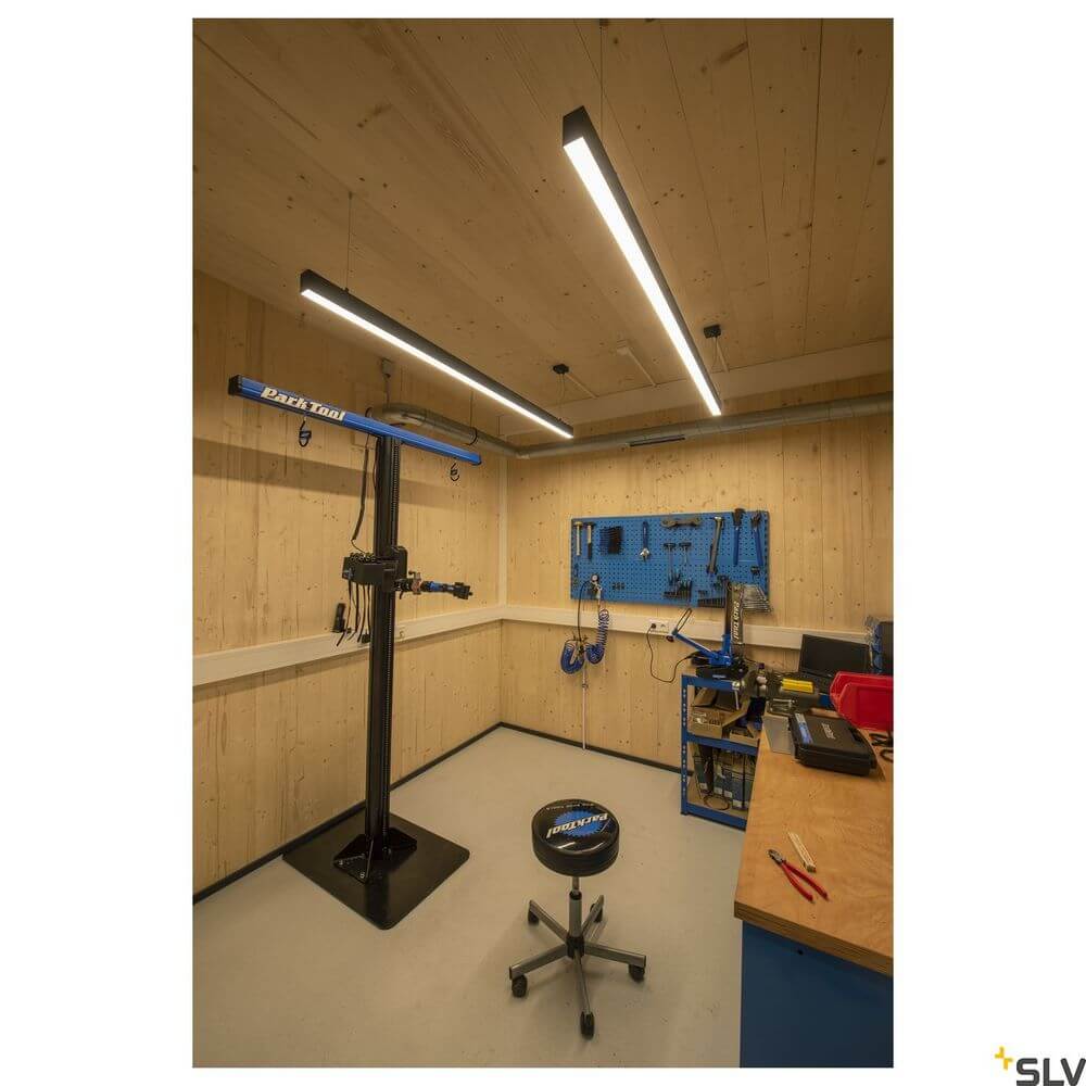 Glenos 2m Pendellampe Schwarz 4000K in moderner Werkstatt mit Holzdecke und Werkzeugstation.