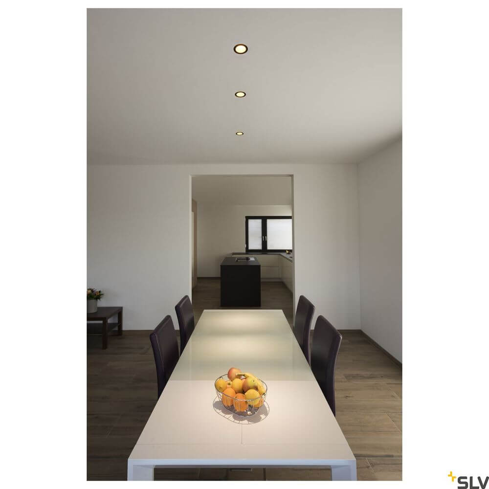 Horn Magna Einbaulampe 3000K Schwarz, Gold über einem modernen Essbereich mit einem Tisch und Stühlen.