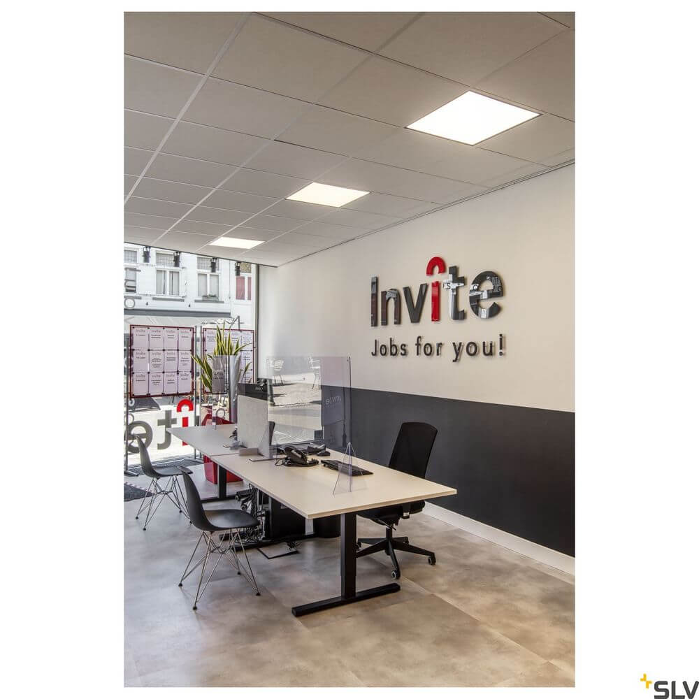 Moderne Büroumgebung mit LED-Panels, Schreibtisch und Schutzwand für Gesundheit und Sicherheit.