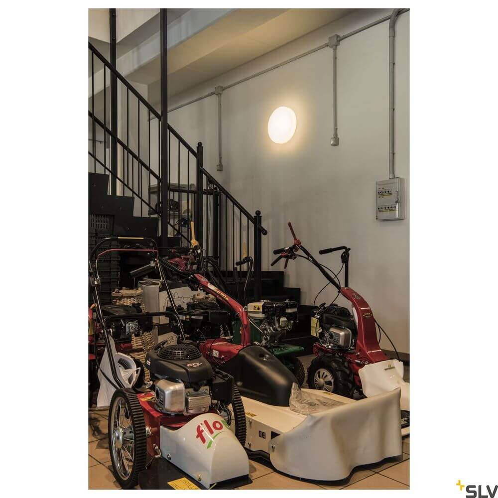 Lipsy 50 Drum LED Deckenlampe Dali Weiß 3000-4000K beleuchtet einen Raum mit verschiedenen Maschinen.