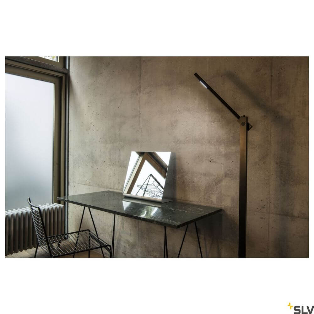 Mecanica Plus FL Büro-Stehlampe 2700-6500K Schwarz neben einem modernen Schreibtisch mit Spiegel.