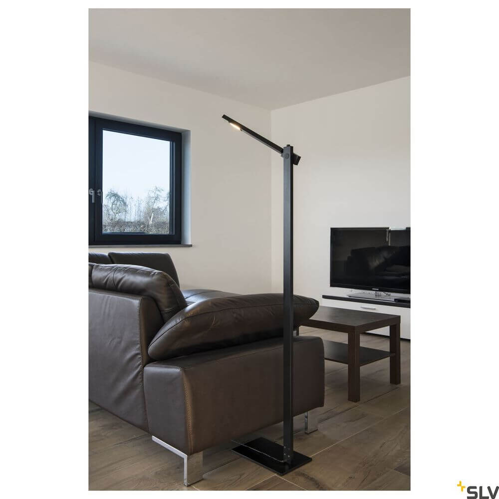 Mecanica Plus FL Büro-Stehlampe 2700-6500K Schwarz in modernem Wohnzimmer neben Couch und Fernseher.