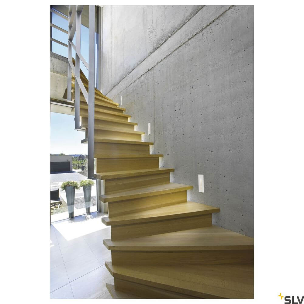 Moderne Treppe mit Holzstufen und indirekter LED-Beleuchtung in einem modernen Raum.