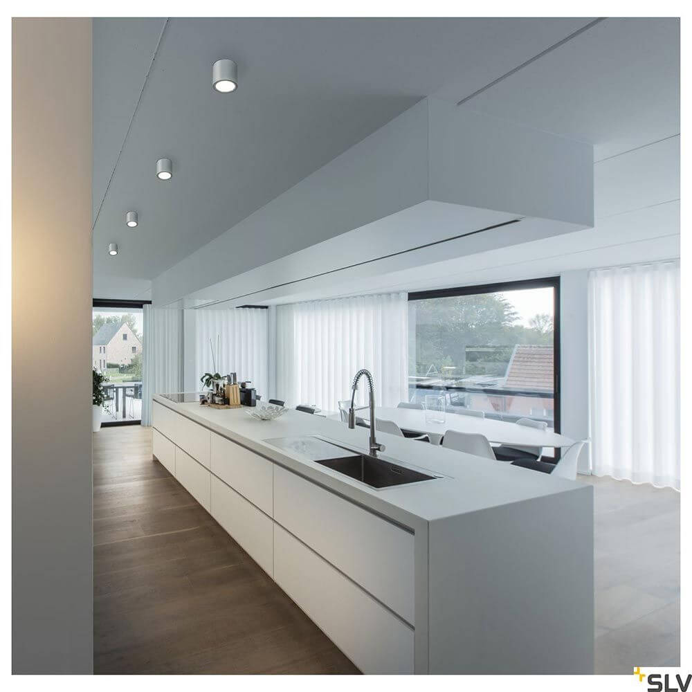 Oculus XS LED Deckenaufbauleuchte Dim-To-Warm in moderner Küchenumgebung mit Kücheninsel und Fensterfront.