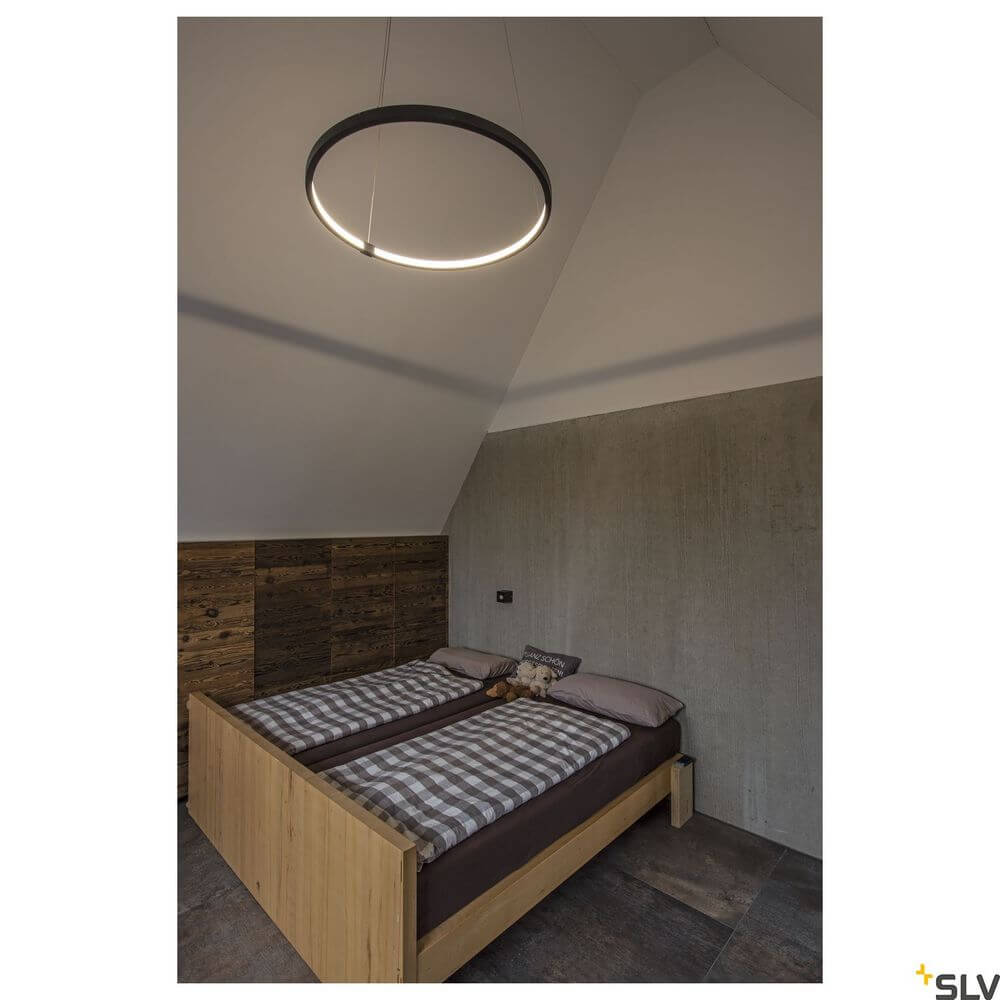 Moderne Pendelleuchte One 80 Dali in Schwarz über Holzbett im Schlafzimmer, warmes Licht 3000-4000K.