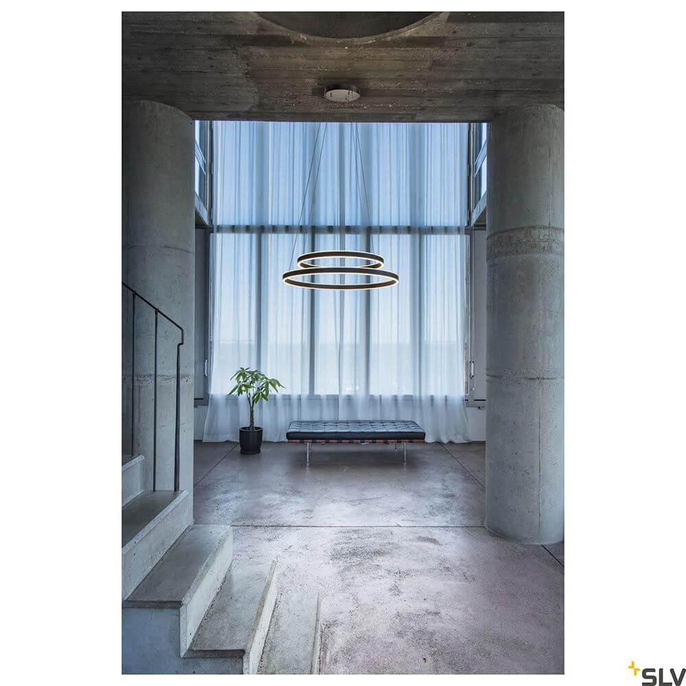 One LED Pendelleuchte Double Dali Up&Down in modernem Raum mit zahlreichen Fenstern.