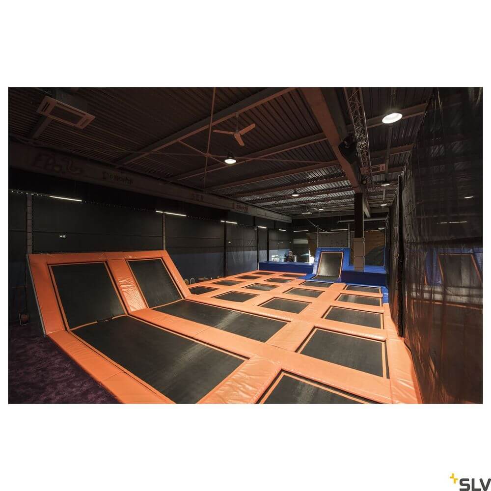 Trampolinbereich in einer Indoor-Jumping-Anlage mit orangefarbenen Trampolinen auf schwarzem Untergrund.