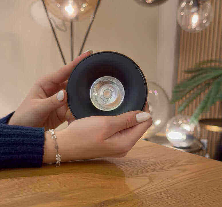 Beleuchtungslampe in der Hand, modernes Design mit klaren Linse und Holzoberfläche, stilvolle Inneneinrichtung