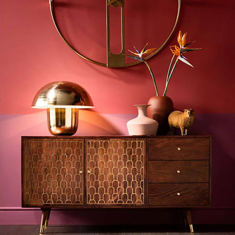 Schicke Tischleuchte Mushroom Messing auf einem Sideboard, umgeben von Pflanzen und Dekoration in einem modernen Wohnraum.