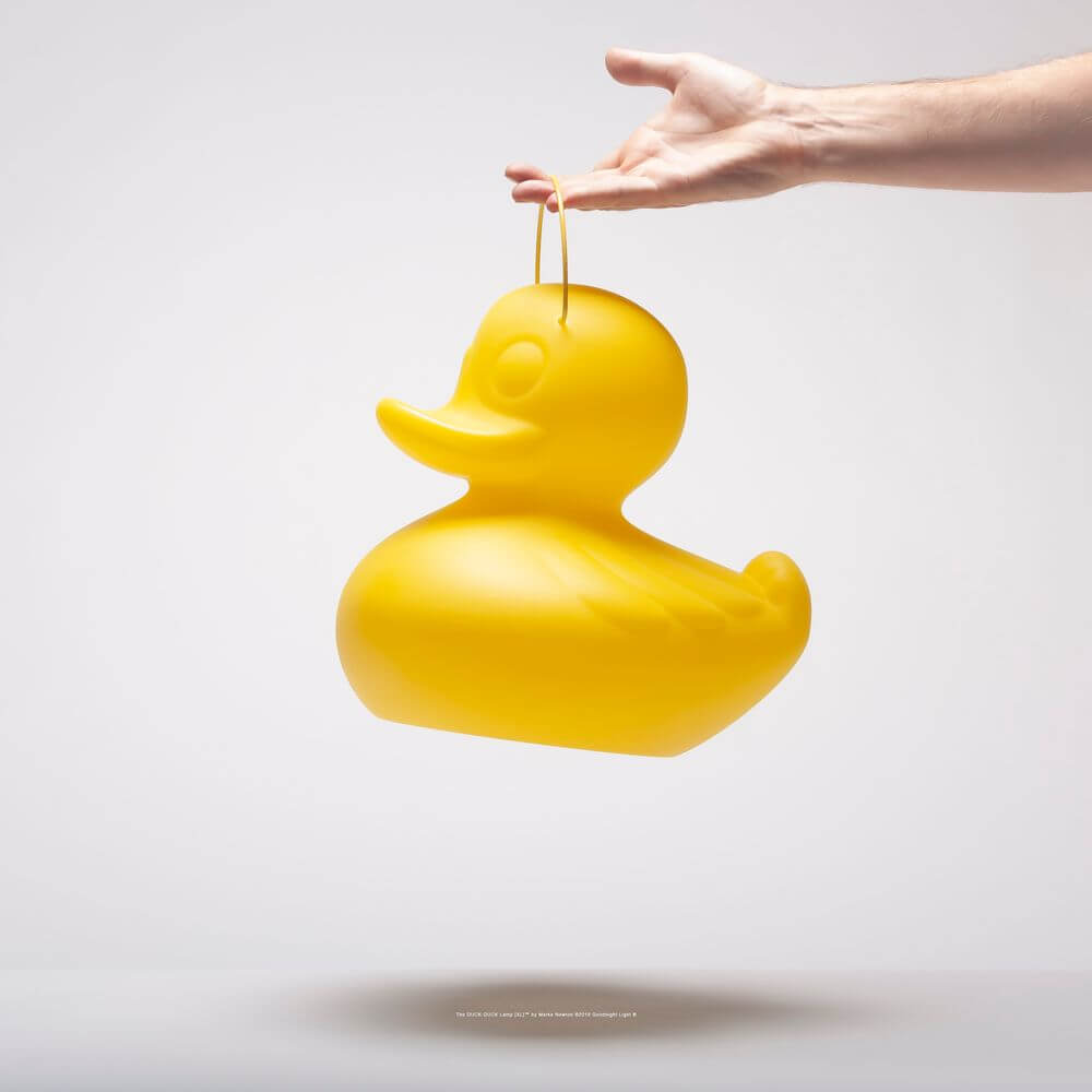 Schwimmfähige Akku-LED-Leuchte Duck-Duck S Gelb wird von einer Hand gehalten.