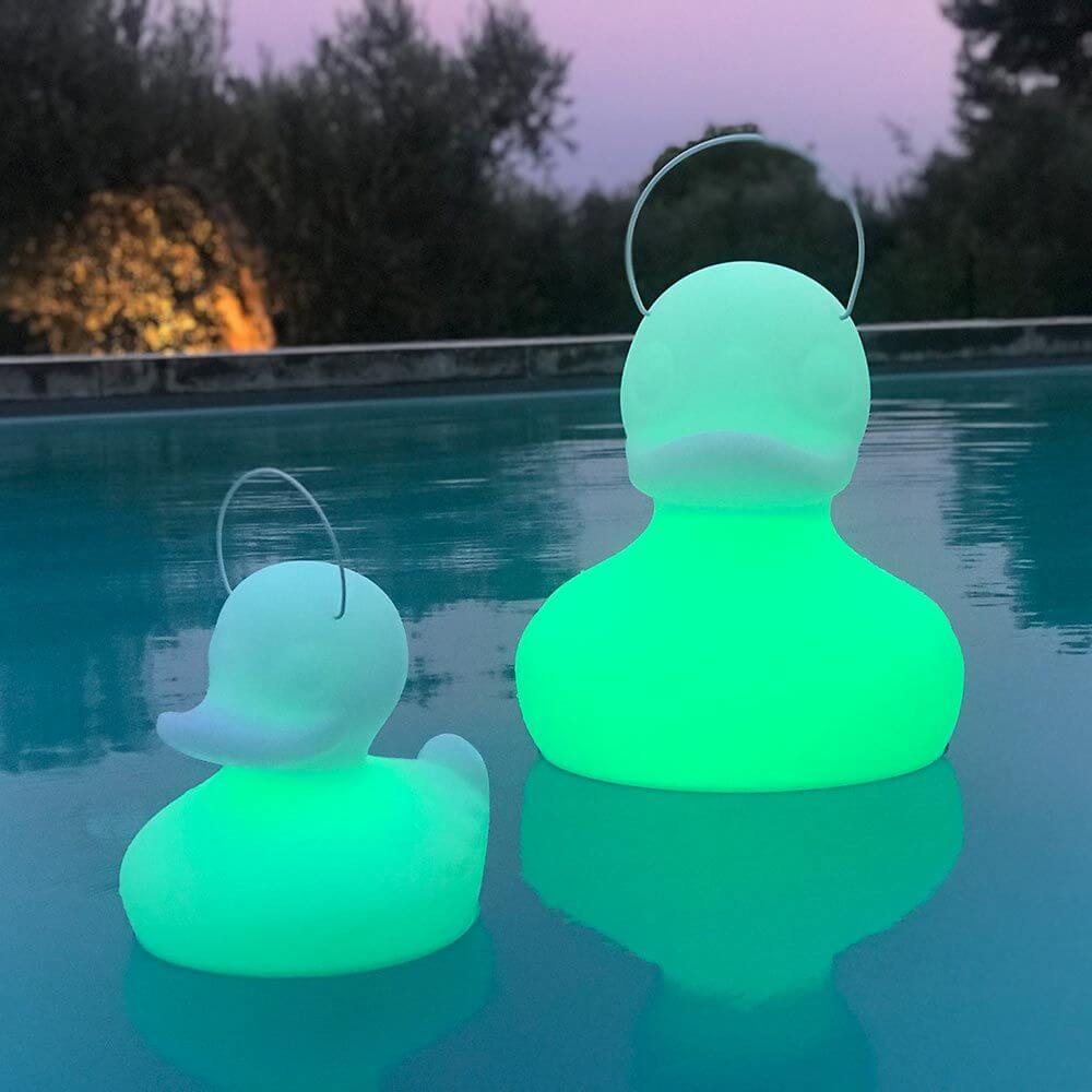 Schwimmfähige Akku-LED-Leuchte Duck-Duck S Gelb in schwimmender Position im Wasser bei Dämmerung.