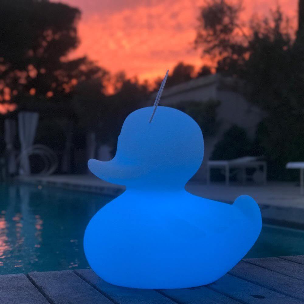 Schwimmfähige Akku-LED-Leuchte Duck-Duck S Gelb am Pool bei Sonnenuntergang