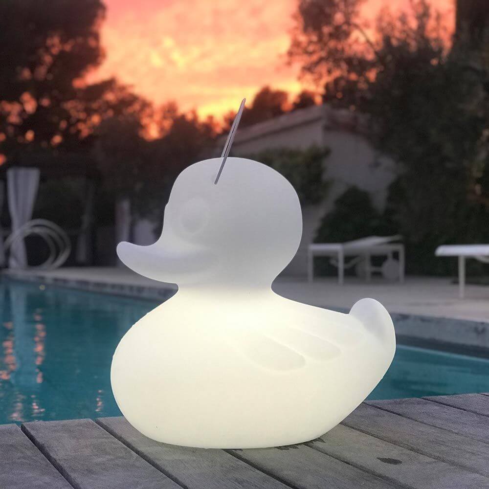 Schwimmfähige Akku-LED-Leuchte Duck-Duck S Gelb am Pool bei Sonnenuntergang