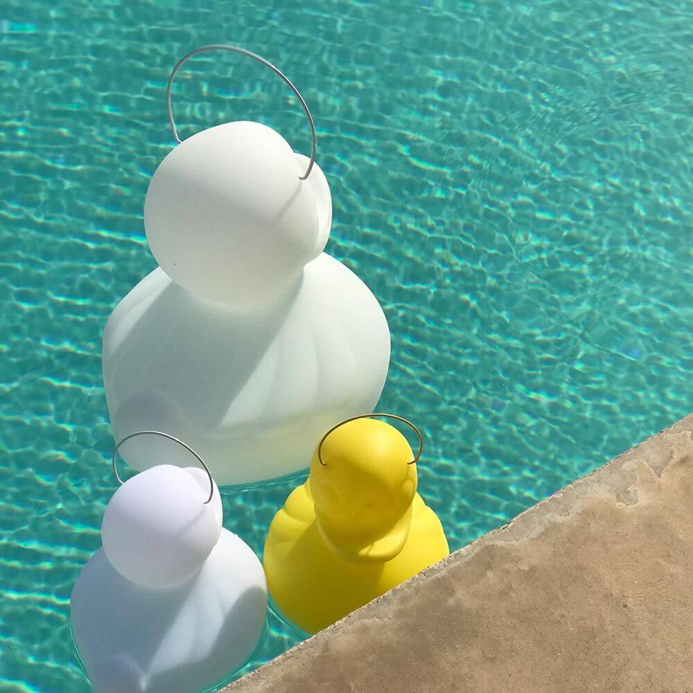 Schwimmfähige Akku-LED-Leuchte Duck-Duck S in Weiß und Gelb im Pool, ideal für den Außenbereich.