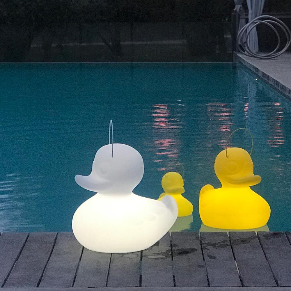 Schimmfähige Akku-LED-Ente Duck-Duck S in Weiß und Gelb schwimmt im Pool, dekorative Gartenbeleuchtung.