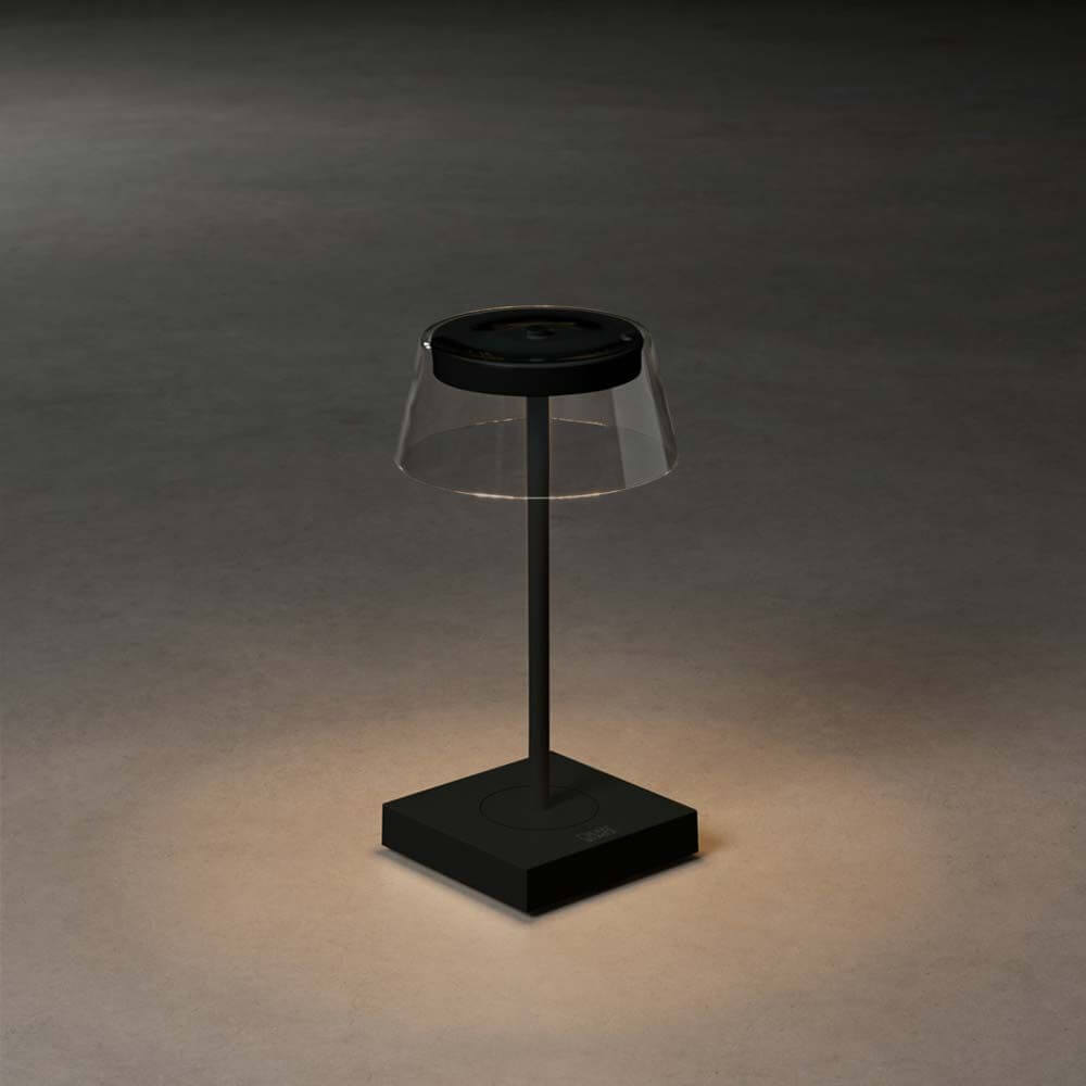Scilla LED Akku Tischleuchte IP54 auf einem stilvollen Tisch mit dimmbarem Licht und USB-Ladeanschluss.