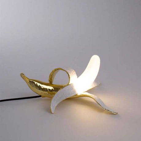 Seletti Banana Dewey Tischleuchte in goldener Bananenform mit stilvollem Design und sanfter Beleuchtung.