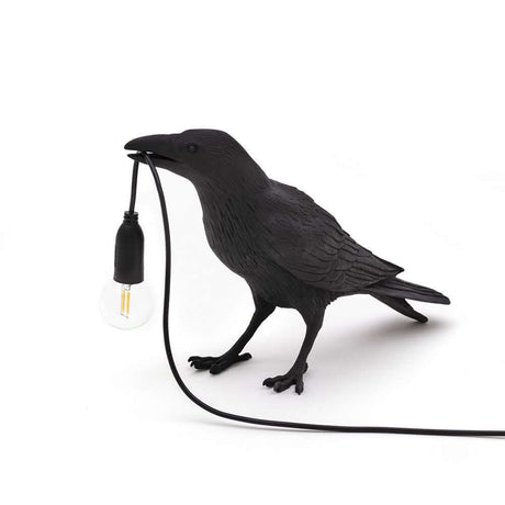 Lampe de table d'extérieur Seletti Bird en forme de corbeau épuré avec une ampoule.