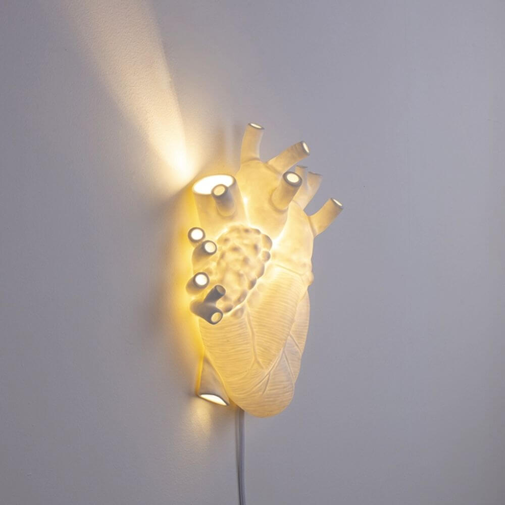 Seletti Heart Wandleuchte & Vase an einer Wand, strahlt weiches Licht und schafft romantische Stimmung.