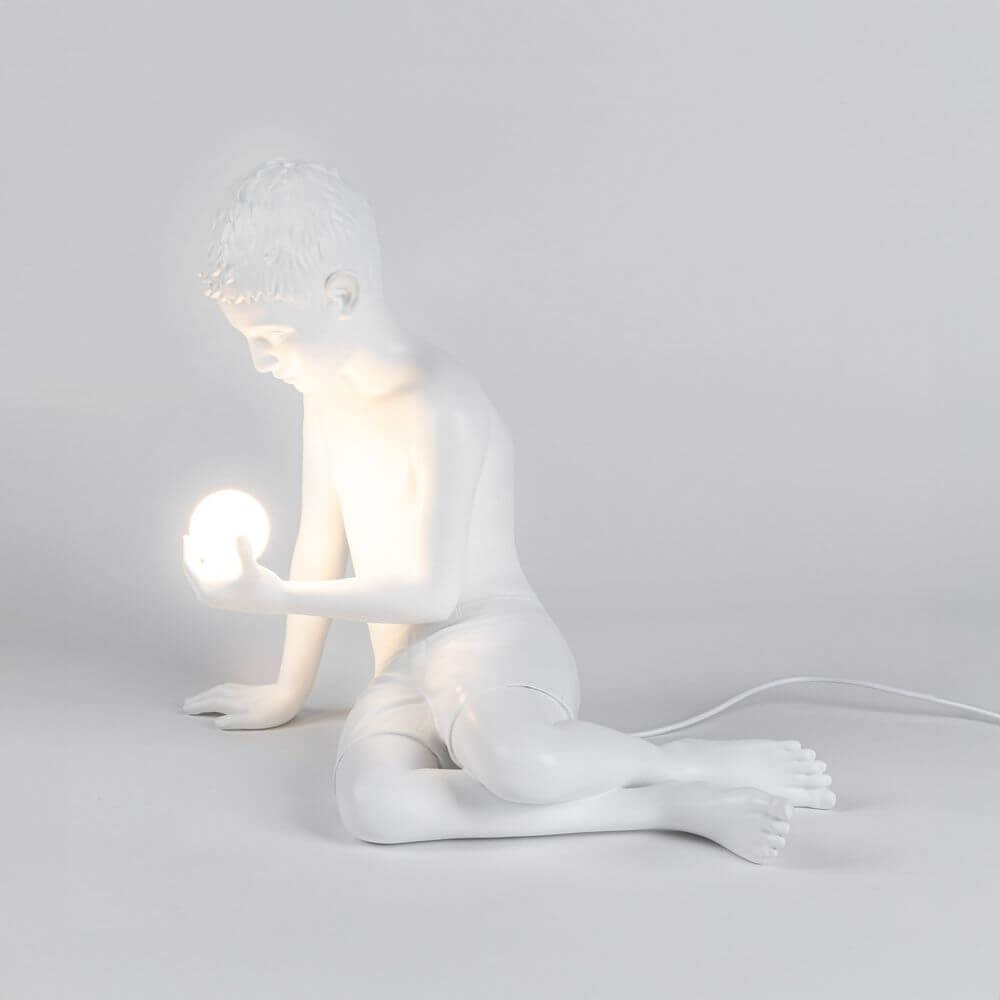 Seletti Innerflow Mini LED-Dekoleuchte Junge Harz – weißer sitzender Junge hält leuchtende Kugel als Deko- und Stimmungslicht