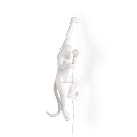Applique extérieure suspendue Seletti Monkey main gauche avec singe blanc tenant une ampoule.