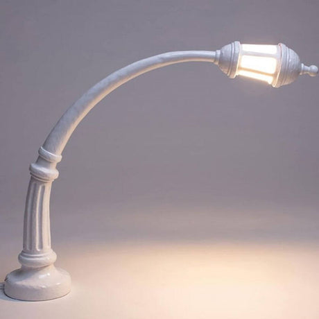 Elegant Seletti Street gulvlampe og buelampe med svingete form og varmt lys.