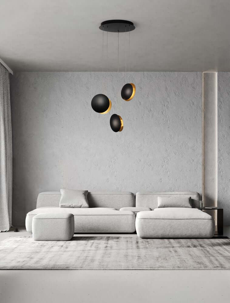 Shell LED Pendelleuchte 3-flammig Ø 48cm 3000K Schwarz, Gold im modernen Wohnraum mit Couch.