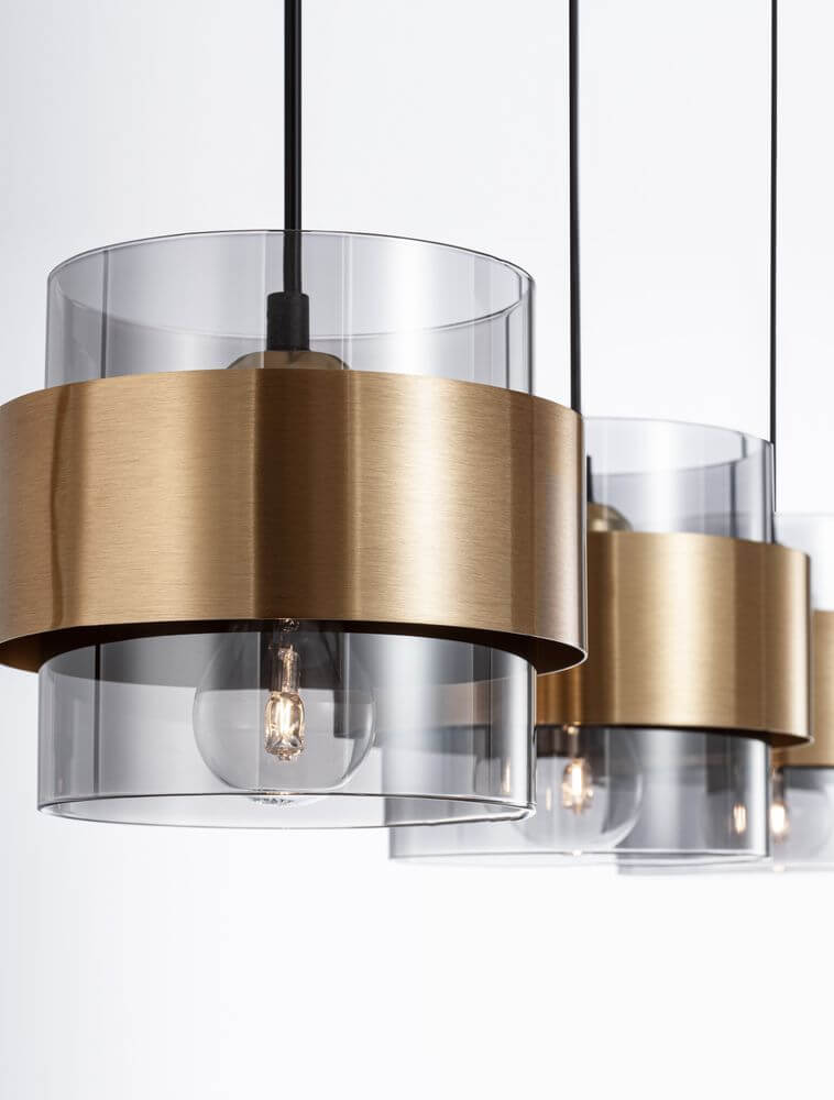 Sianna Pendelleuchte Balken 70cm 3-flammig Gold, Rauch, Schwarz mit goldenem Metallring und rauchigem Glaszylinder.