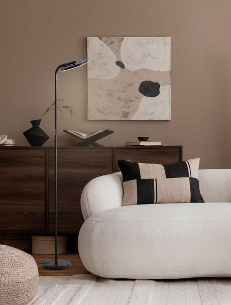 Sinkro LED floor lamp Ø 25.2 cm 3000K with foot switch in a modern living room setting.