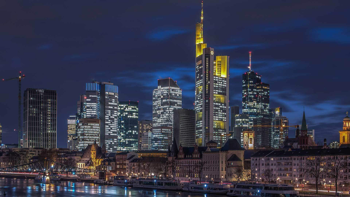 Frankfurter Skyline bei Nacht, beeindruckende Hochhäuser und reflektierendes Wasser in der Stadt Frankfurt.