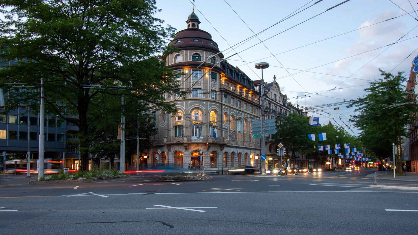 Blick auf ein historisches Gebäude mit Straßenbeleuchtung und Bäumen in der Dämmerung, Stadtansicht.