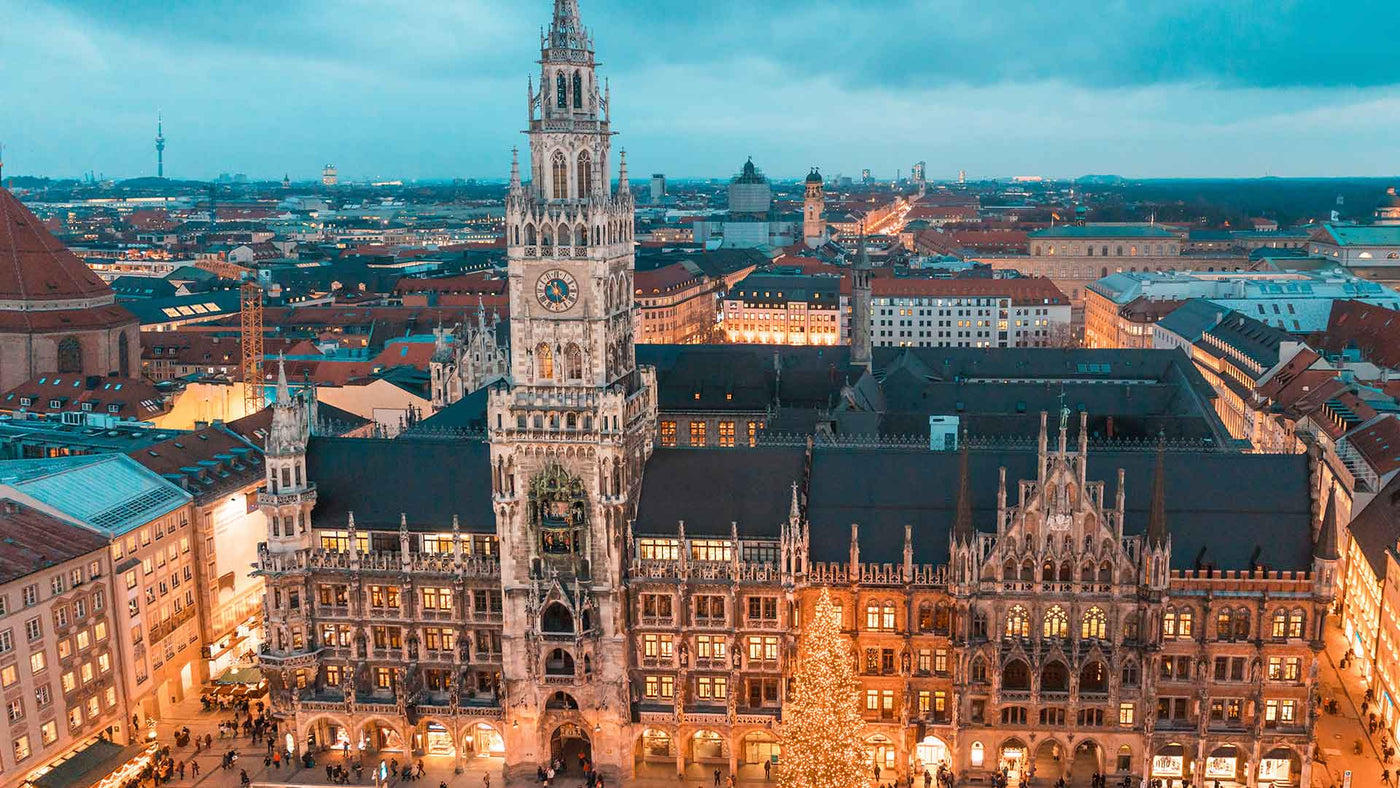 Weihnachtlicher Blick auf das Münchener Rathaus mit Weihnachtsbaum und beleuchteten Straßen.