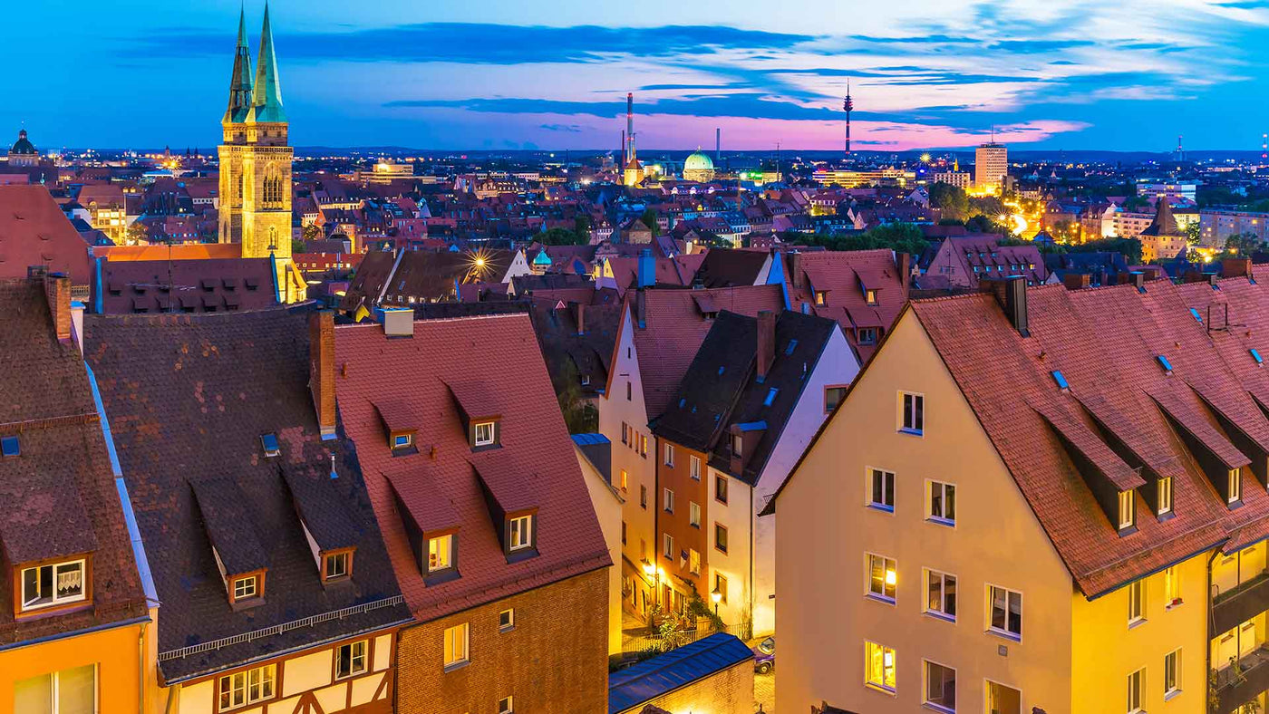 Blick über die Dächer Nürnbergs bei Dämmerung, mit historischen Gebäuden und lebendiger Stadtansicht.