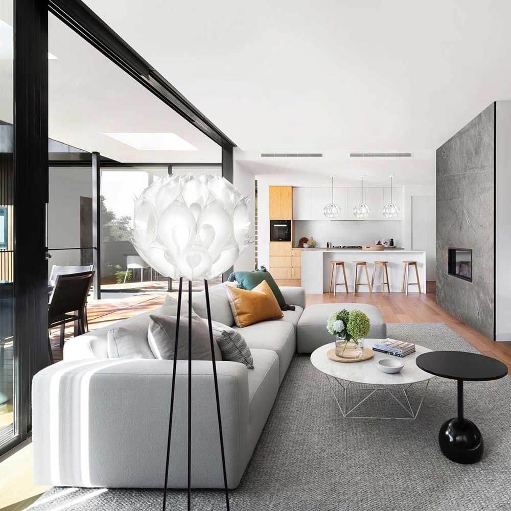 Slamp Dreibein-Stehlampe Flora in modernem Wohnzimmer mit gemütlicher Couch und eleganter Einrichtung.
