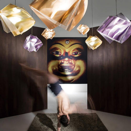 Lampa wisząca Slamp Gemmy Prisma Kolor Złoty w nowoczesnym pomieszczeniu z fascynującymi refleksami światła.