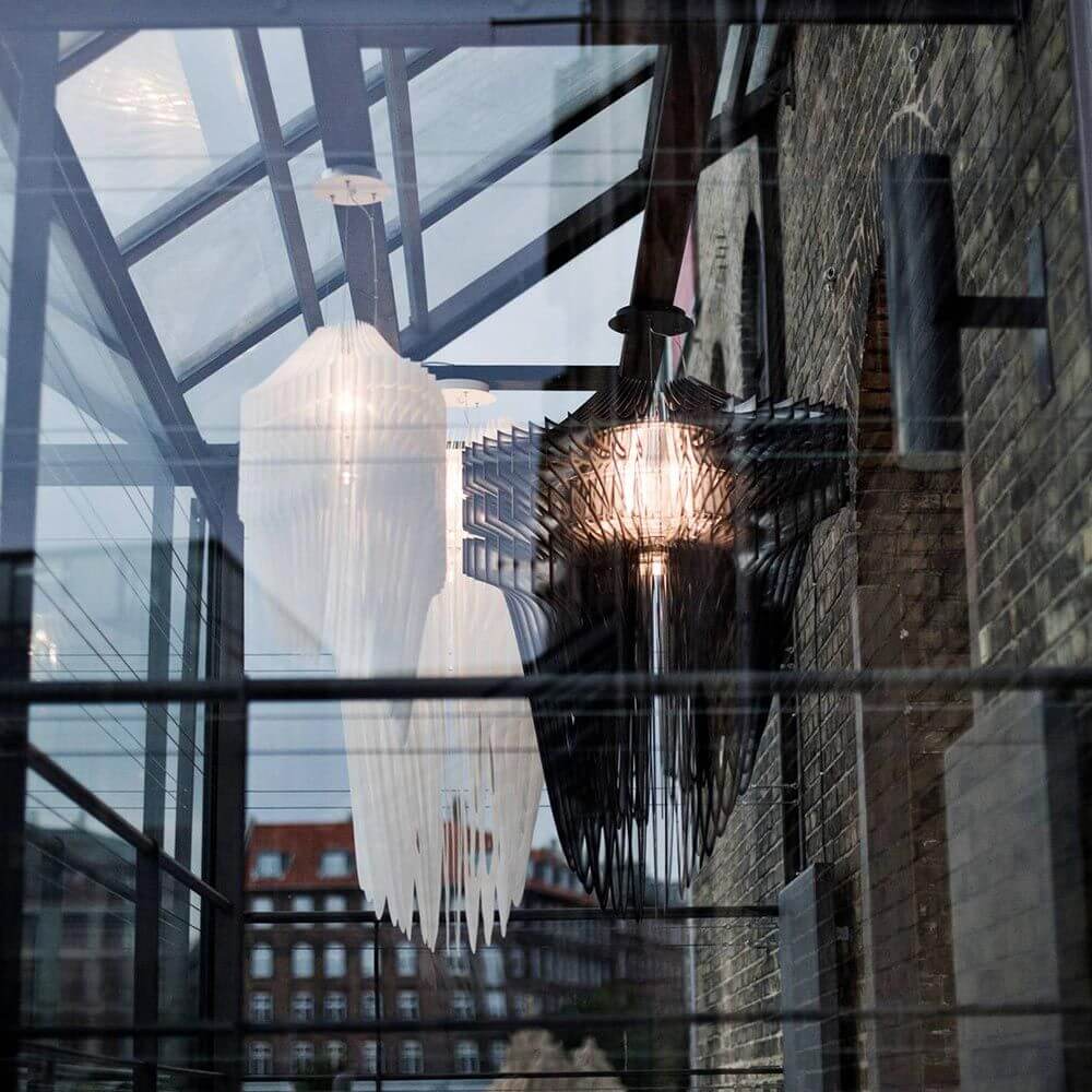 Slamp Hängeleuchte Aria Schwarz, Transparent in modernem Innenraum mit Glasdach und Ziegelwänden.
