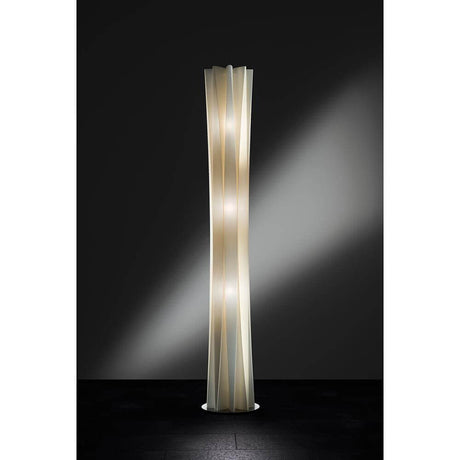 Moderna lampada da terra Slamp Bach XXL Oro in forma elegante e slanciata con luce calda su sfondo scuro.