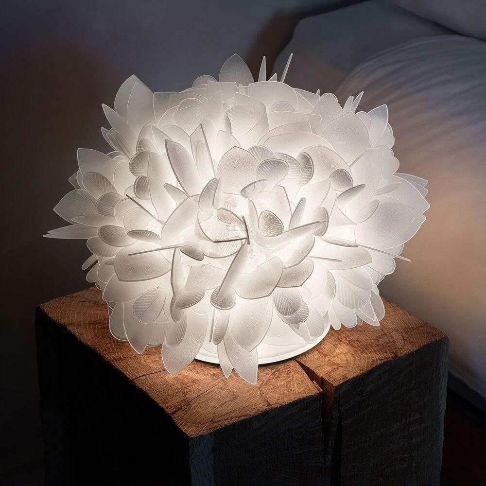 Slamp Tischlampe Veli Foliage mit floralem Design auf einem Holztisch, ideal für eine elegante Einrichtung.