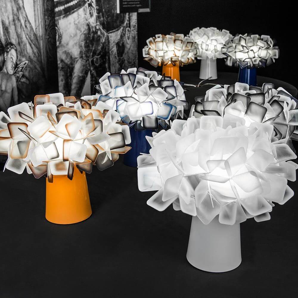 Slamp Tischleuchte Clizia Orange und weitere Modelle in verschiedenen Farben auf einem Tisch