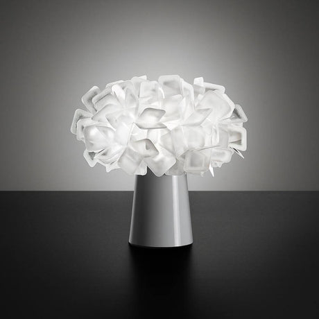 Slamp bordslampa Clizia Vit med batteri på ett bord, design inspirerad av naturliga former och ljusreflektioner.