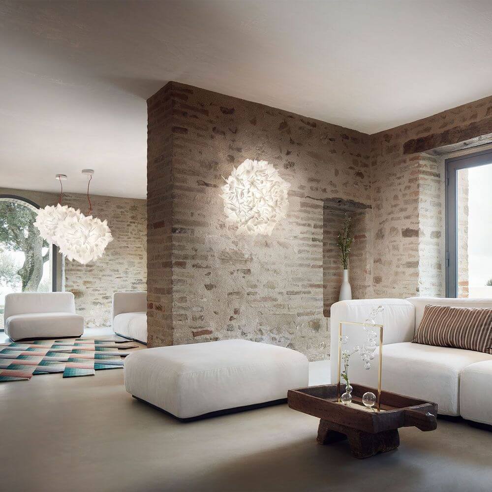 Moderner Wohnraum mit Slamp Wand- & Deckenlampe Veli Foliage und stilvollen Möbeln.