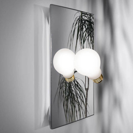 Slamp Wandlampe Idea Glühbirne mit zwei weißen Glühbirnen und spiegelndem Hintergrund.