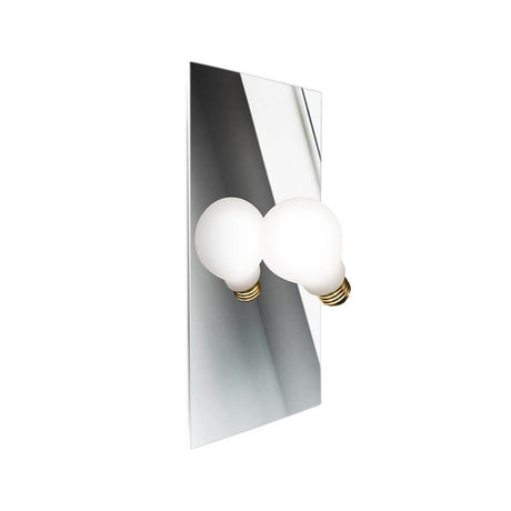 Slamp Wandlampe Idea Glühbirne an einer Wand, mit zwei runden, weißen Glühbirnen und einem spiegelnden Hintergrund.