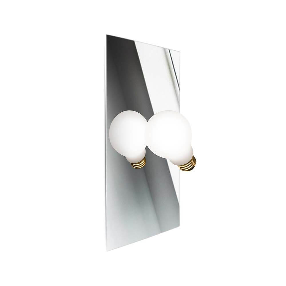 Slamp Wandlampe Idea Glühbirne an einer Wand, mit zwei runden, weißen Glühbirnen und einem spiegelnden Hintergrund.