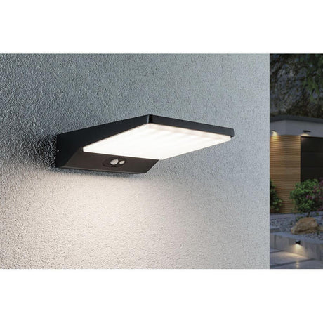Solar LED Außenwandlampe Ronas Bewegungsmelder Grau an einer Wand montiert, strahlend helles Licht.