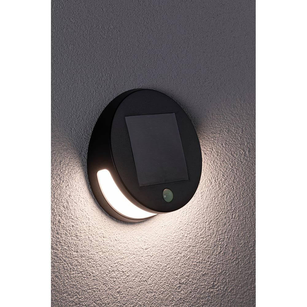 Solar LED Außenwandleuchte Helena Bewegungssensor Anthrazit an einer Wand montiert, mit aktivem Licht.