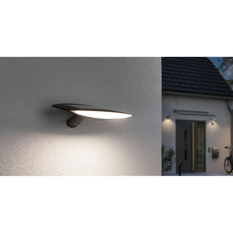 Solar LED outdoor wall light Kiran motion sensor anthracite mounted on a wall with warm light.