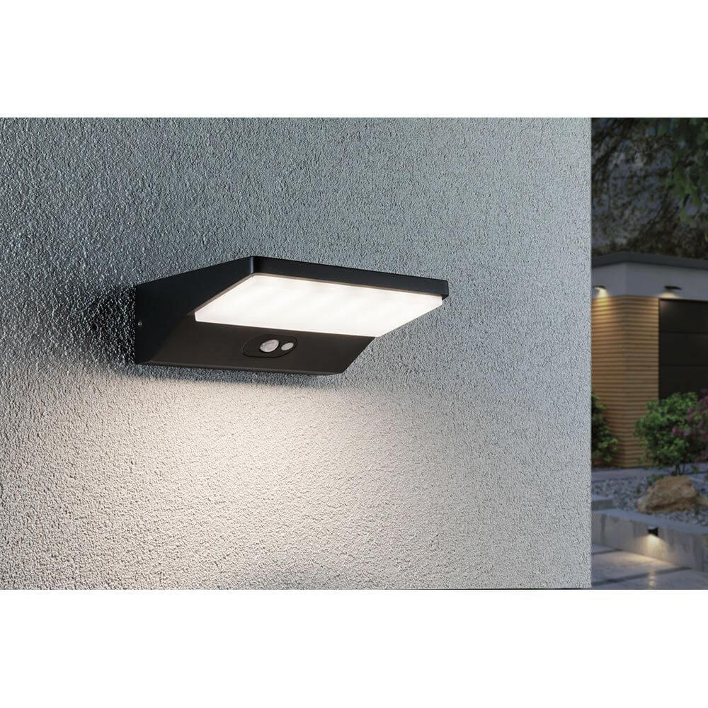 Solar LED Außenwandleuchte Ronas mit Sensor Dunkelgrau an Hauswand montiert, mit Bewegungsmelder und IP44 Schutz.