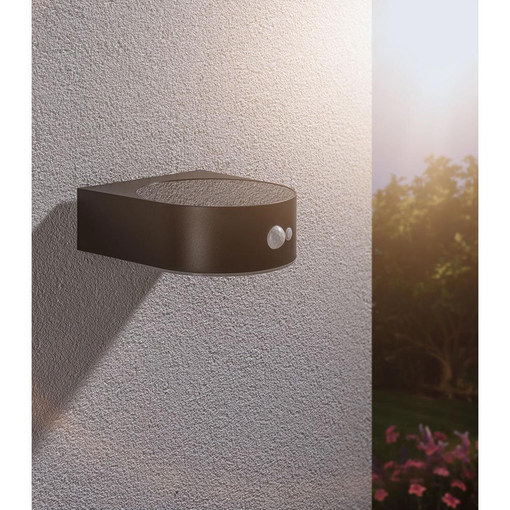 Solar LED Außenwandleuchte Eileen Sensor Schwarz an einer Wand montiert, mit Bewegungsmelder und warmweißem Licht.