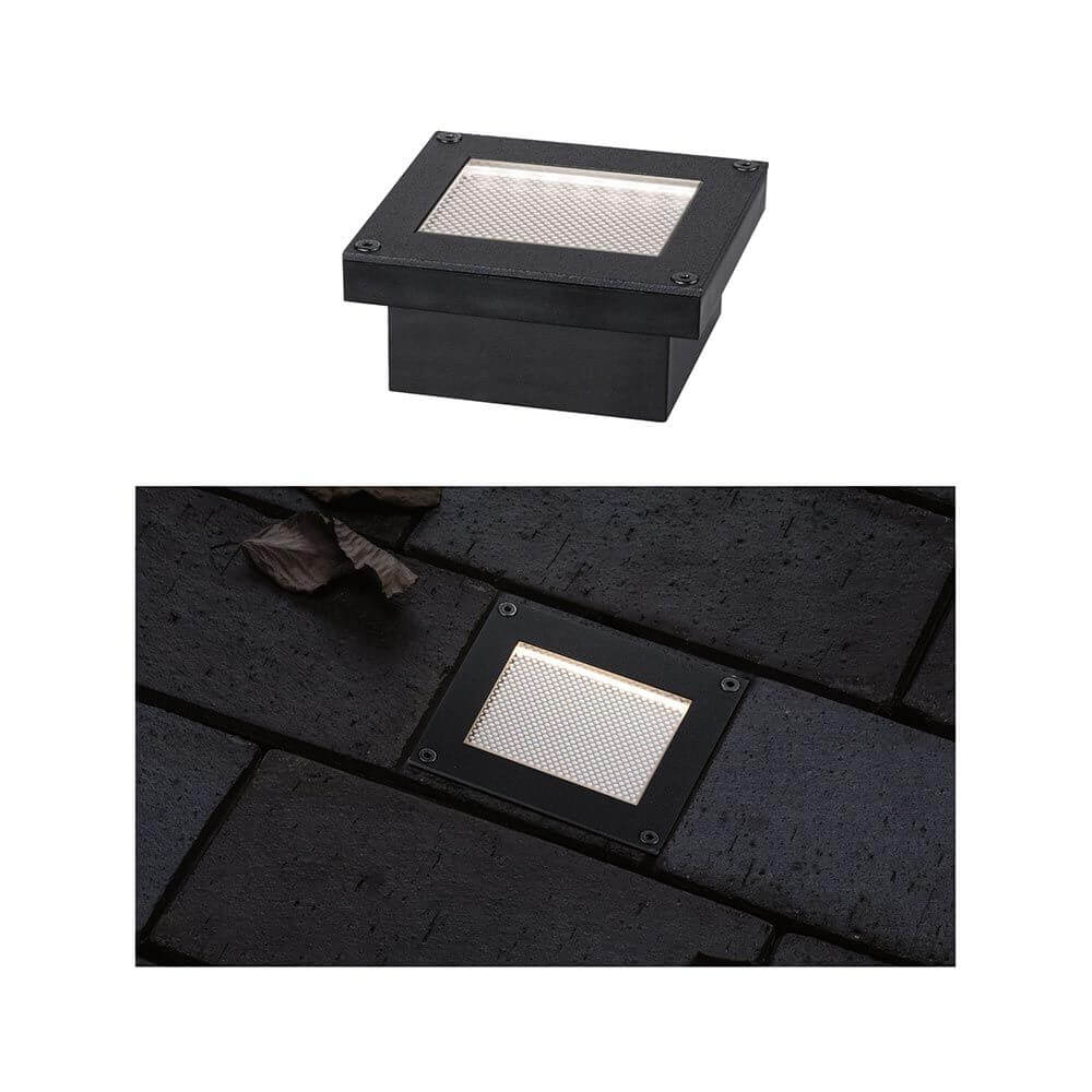 Solar LED Bodeneinbauleuchte Domenic Quadratisch Schwarz IP67 auf Pflasterstein im Dunkeln.